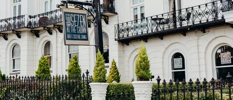 A building with a sign for "SEVEN AT THE CROWN BAR & COCKTAIL LOUNGE".
