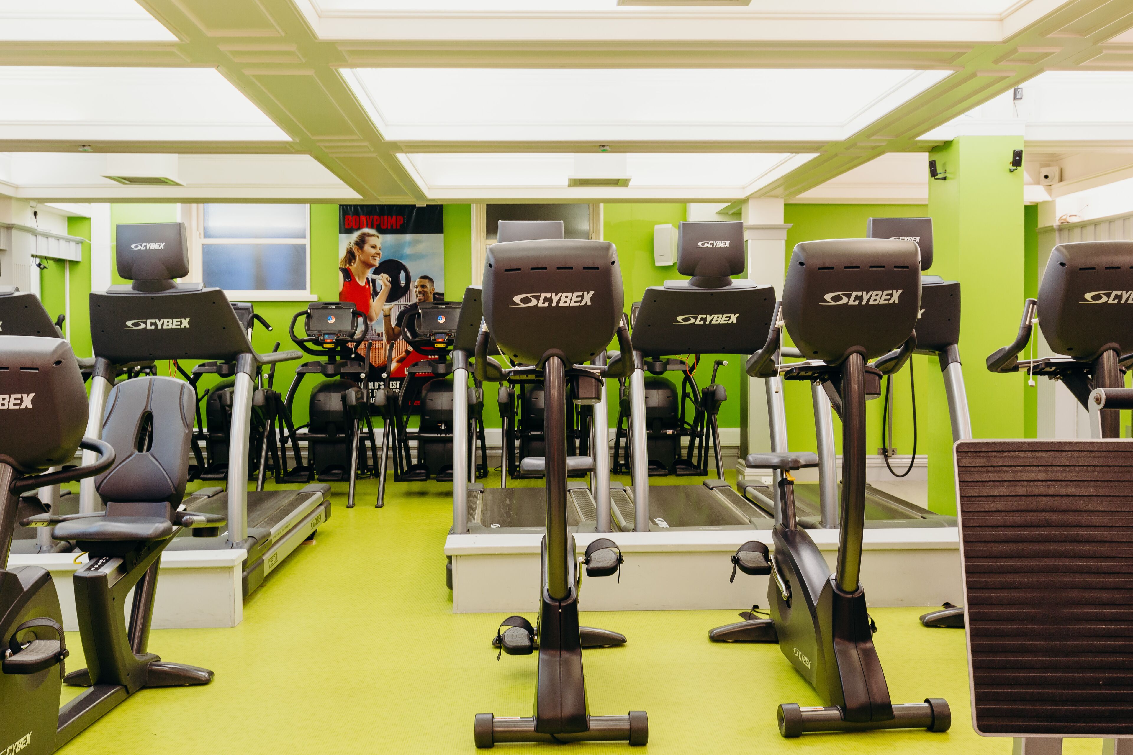 A gym with multiple Cybex elliptical machines, a treadmill, and a stationary bike.