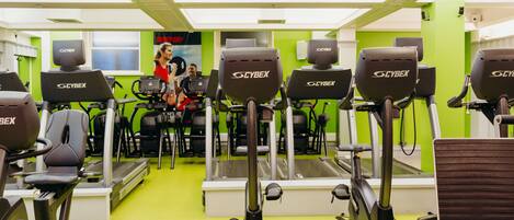 A gym with multiple Cybex elliptical machines, a treadmill, and a stationary bike.
