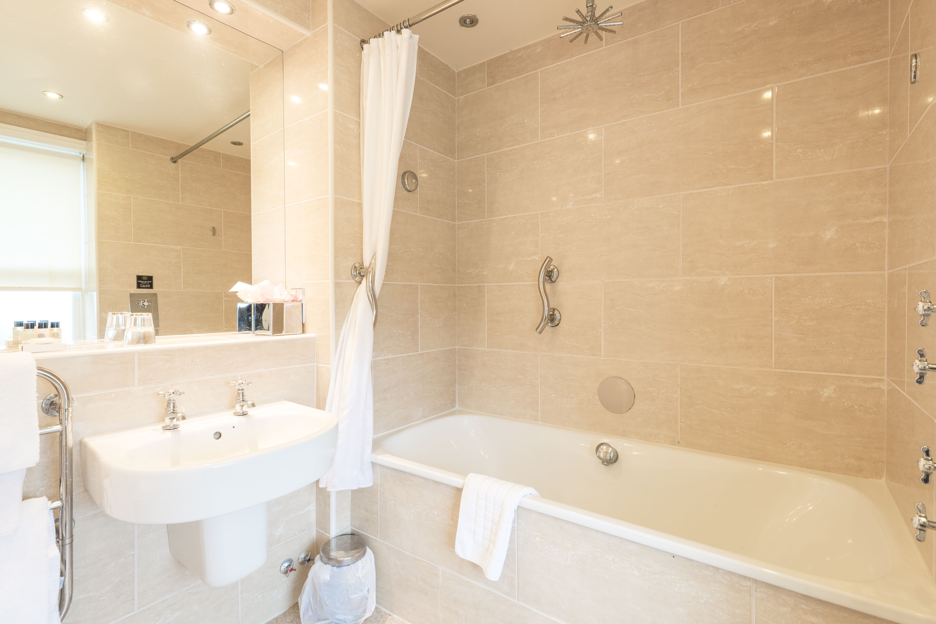 A modern bathroom with a bathtub, a sink, and a shower area.