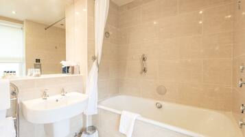 A modern bathroom with a bathtub, a sink, and a shower area.