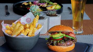 A meal consisting of a burger, fries, and a beer.