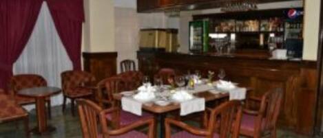 Een restaurant met houten meubels, een bar en uitzicht op de straat.