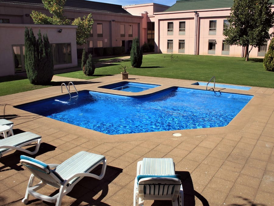 Alberca al aire libre y camastros