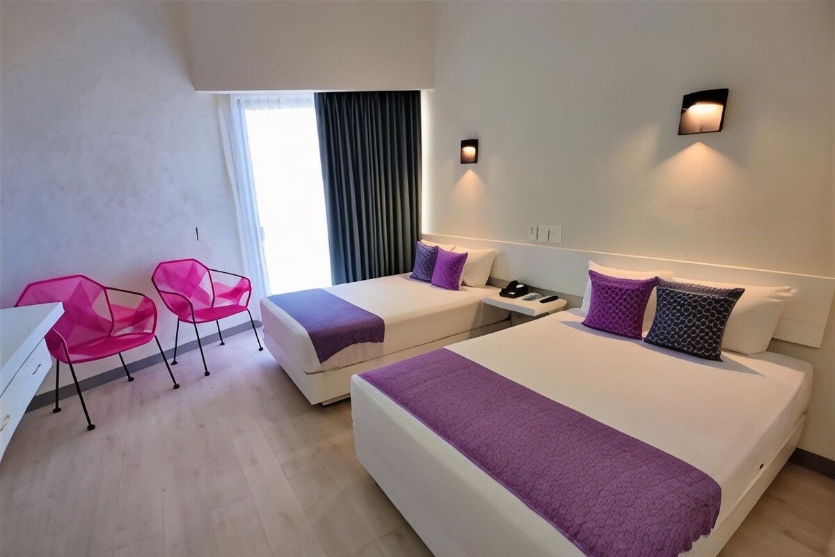 Una habitación de hotel con dos camas, un escritorio y una silla.