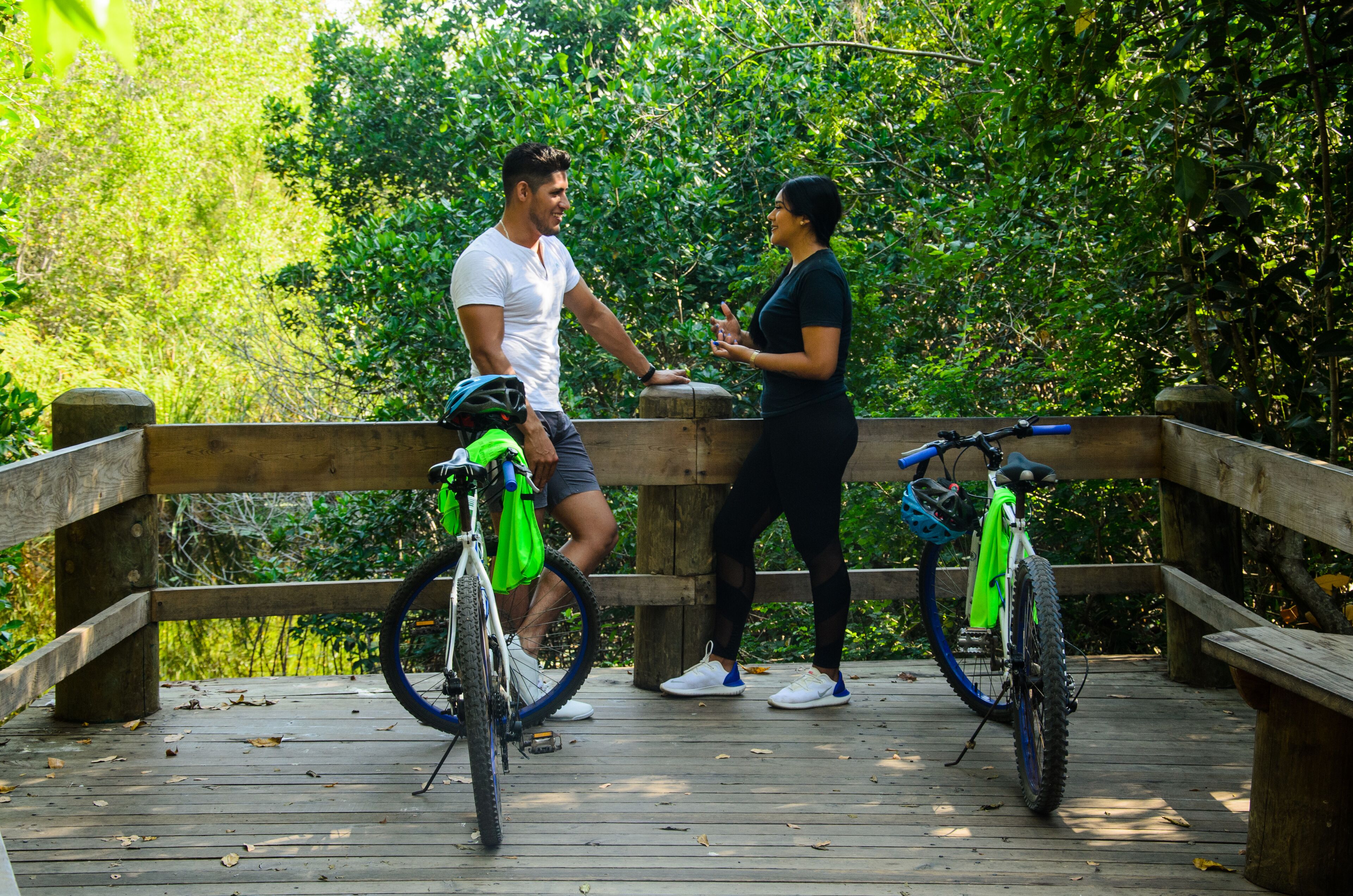 A wooden deck with bicycles and a person conversing.