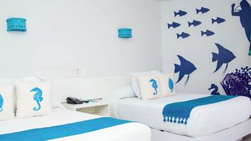 A hotel room with two beds, a nightstand, and a wall decorated with marine life silhouettes.