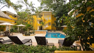Relax by the serene pool surrounded by lush greenery and tropical plants.