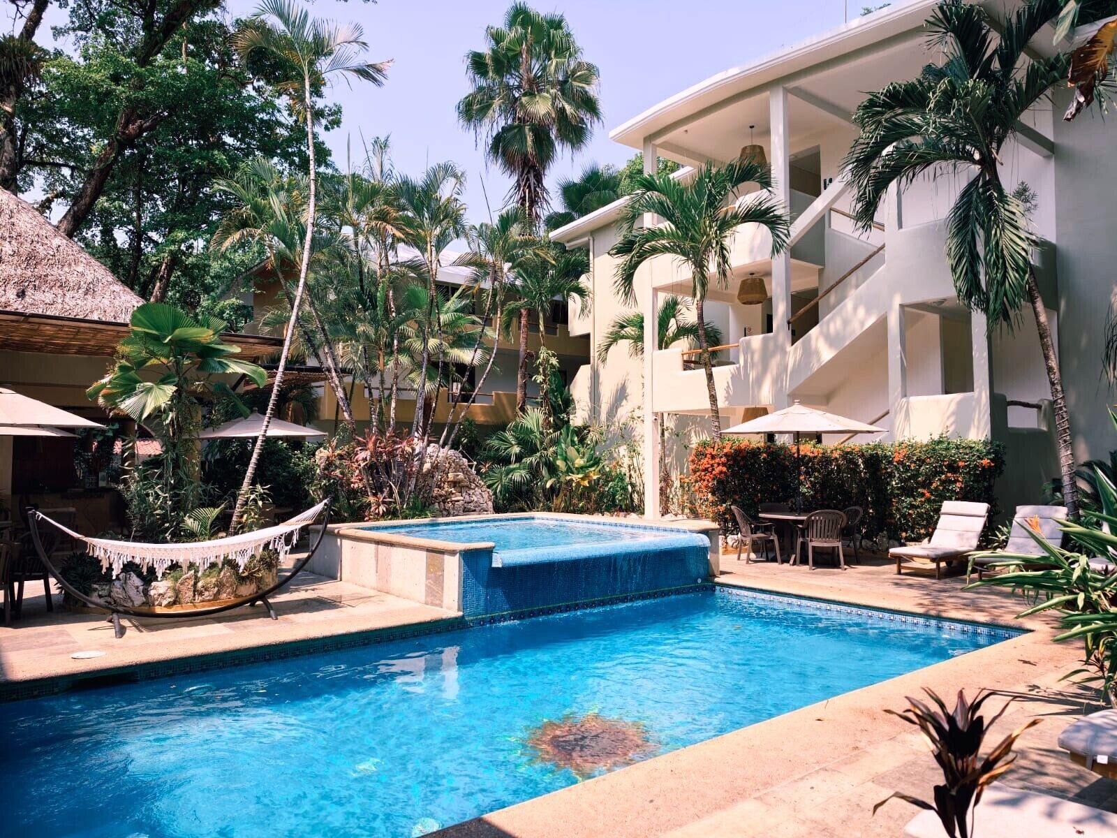 Una piscina al aire libre, sombrillas, tumbonas