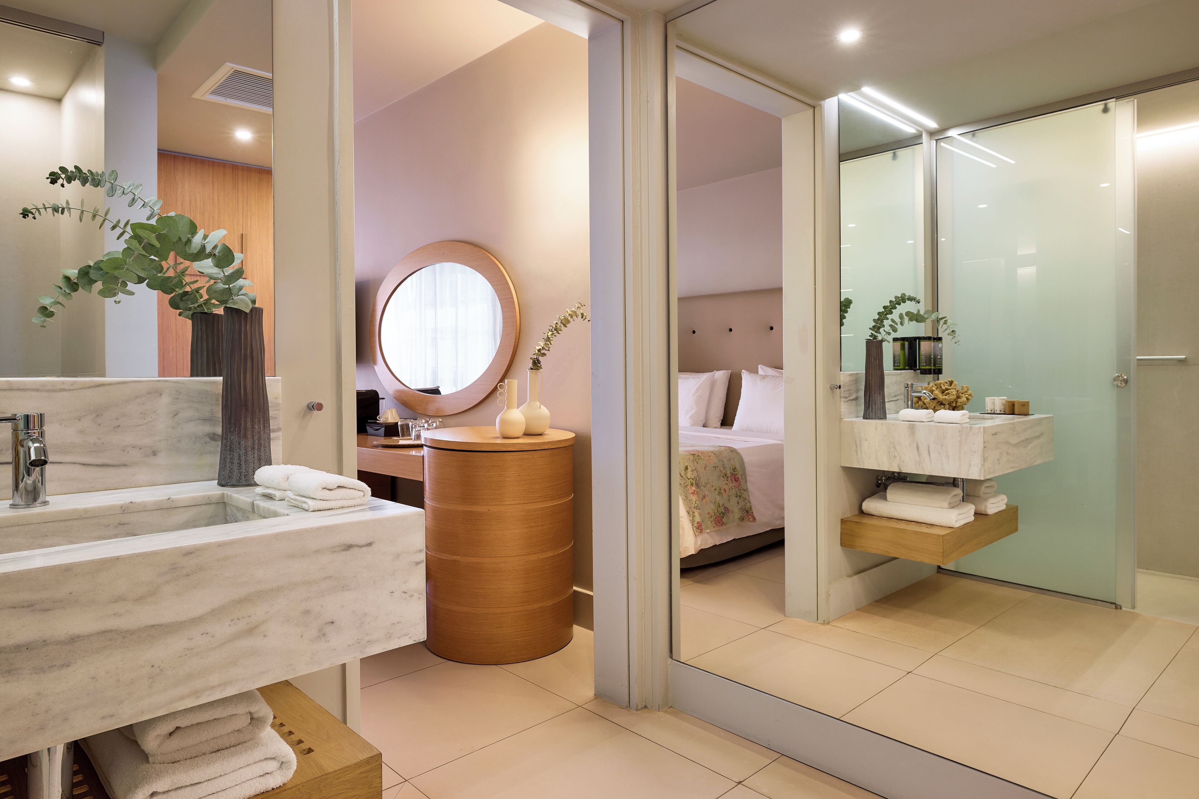 Une salle de bain moderne avec un grand miroir, un miroir rond et un meuble-lavabo en bois.