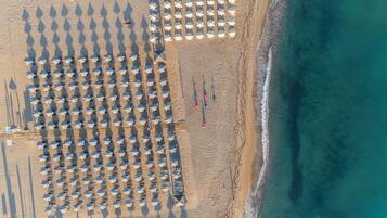 Una playa cerca, sillas reclinables de playa, sombrillas