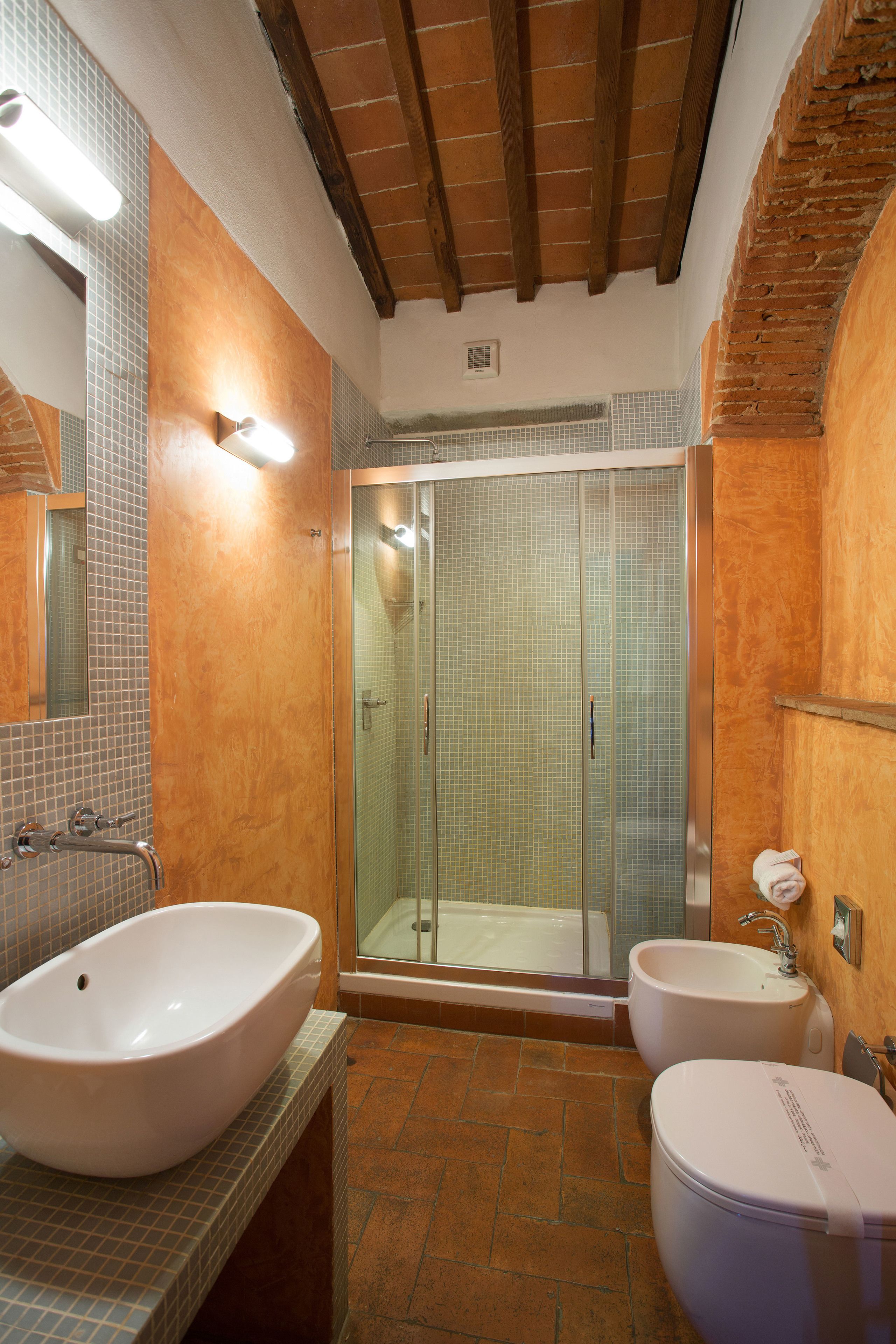 Un baño con una bañera grande, un lavamanos independiente y una zona de ducha con paredes de vidrio.