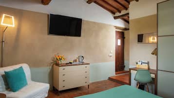 Un dormitorio con cama, cómoda, escritorio con silla, televisor y lámpara.