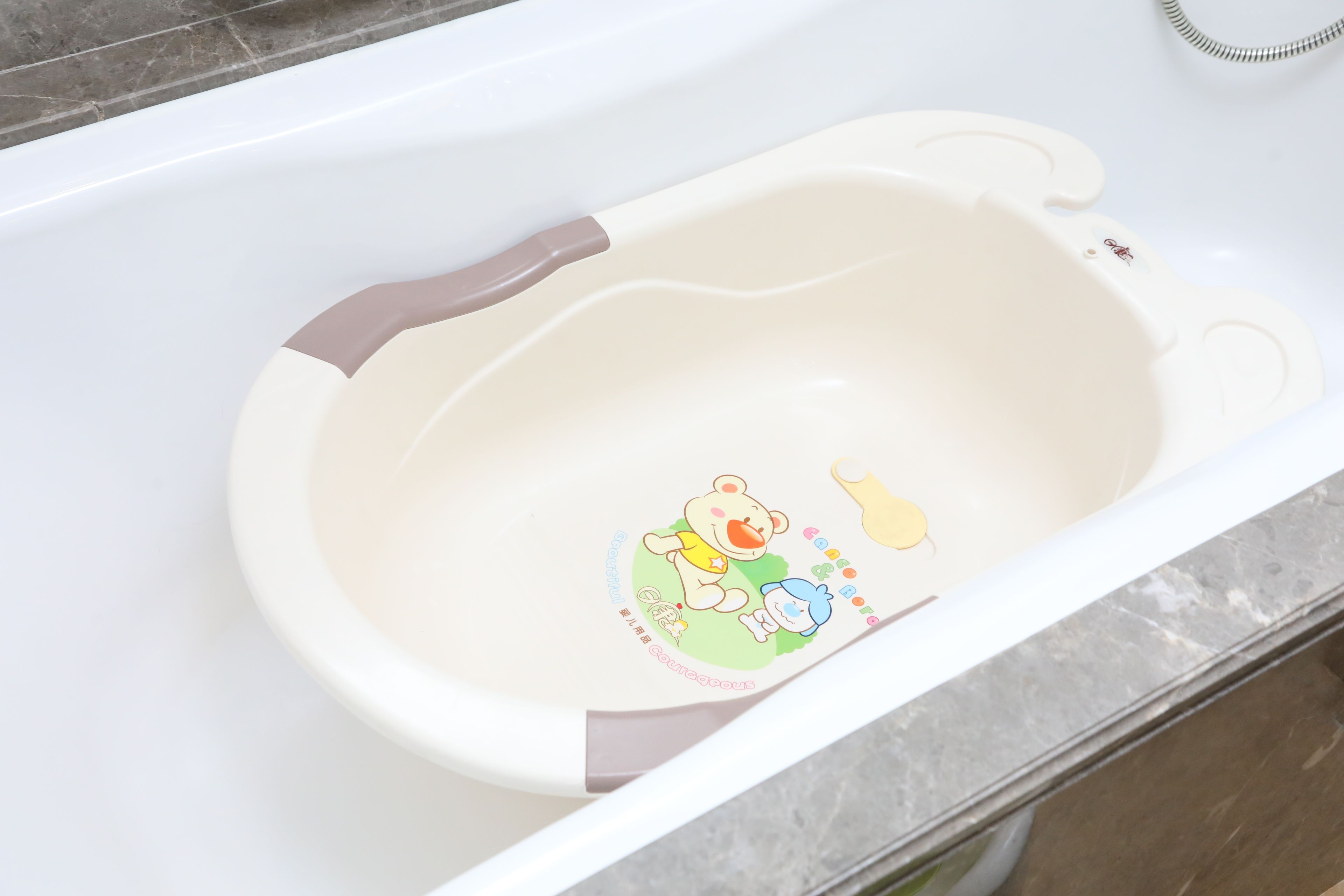 A white bathtub with a bear and a character design on the inner wall.