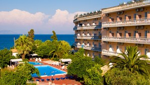 A hotel with a pool, multiple balconies, and a view of the sea. - Potamaki Beach Hotel (Corfu)