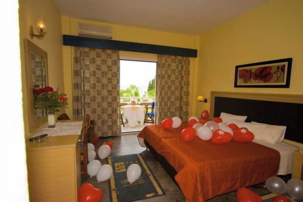 Habitación de hotel con cama, escritorio y vista al exterior.