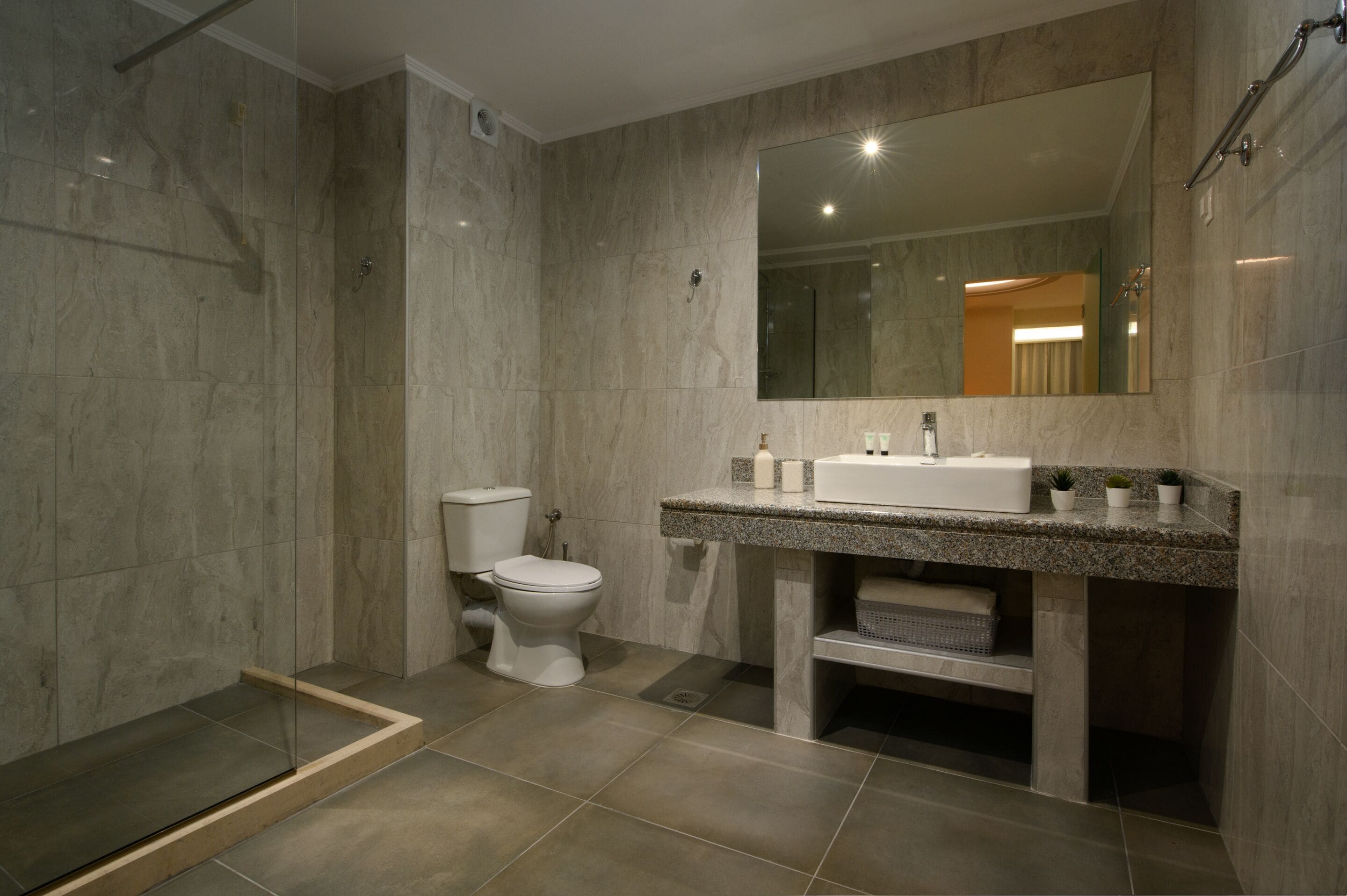 Une salle de bain moderne équipée d’une douche, de toilettes et d’un lavabo.