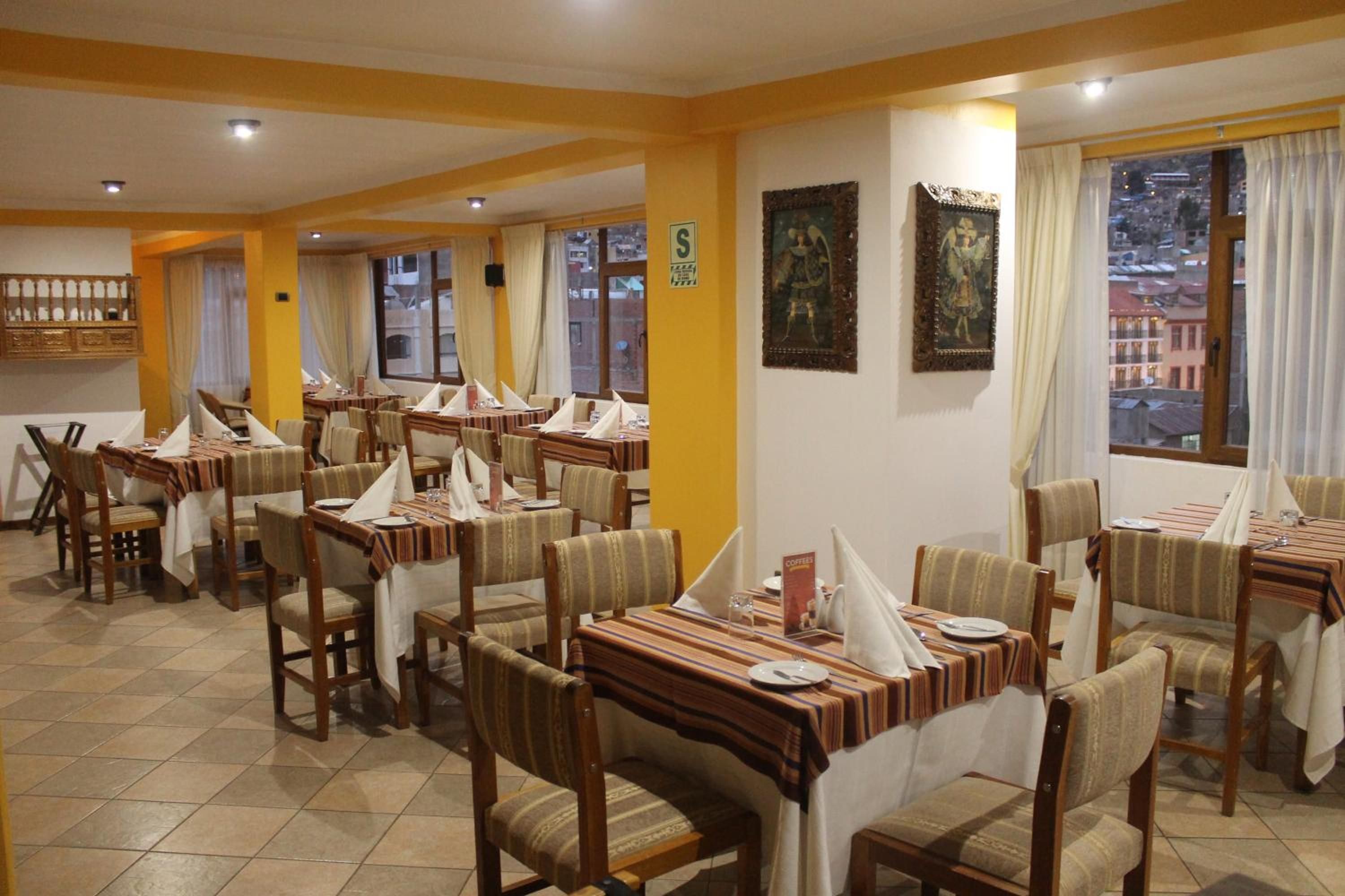 A restaurant with multiple tables and chairs, a tiled floor, and a view of the city through the windows.
