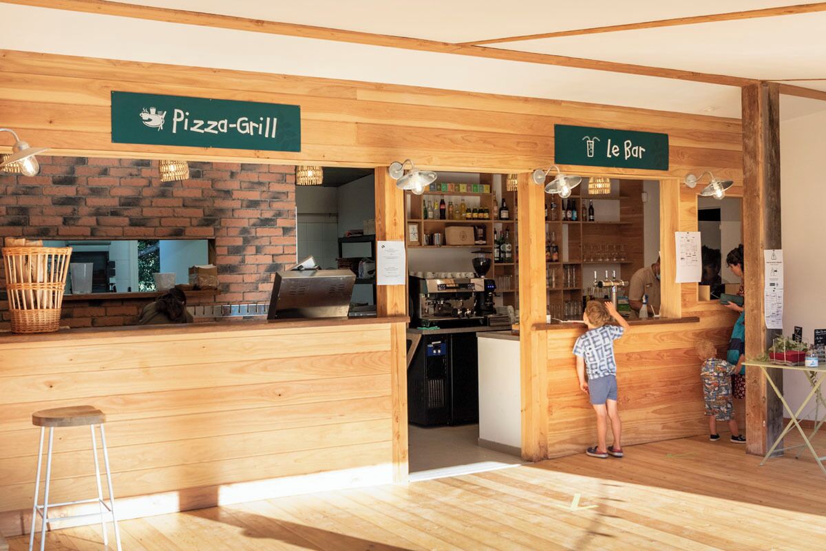 Un restaurante con una parrilla para pizzas y una zona de bar.