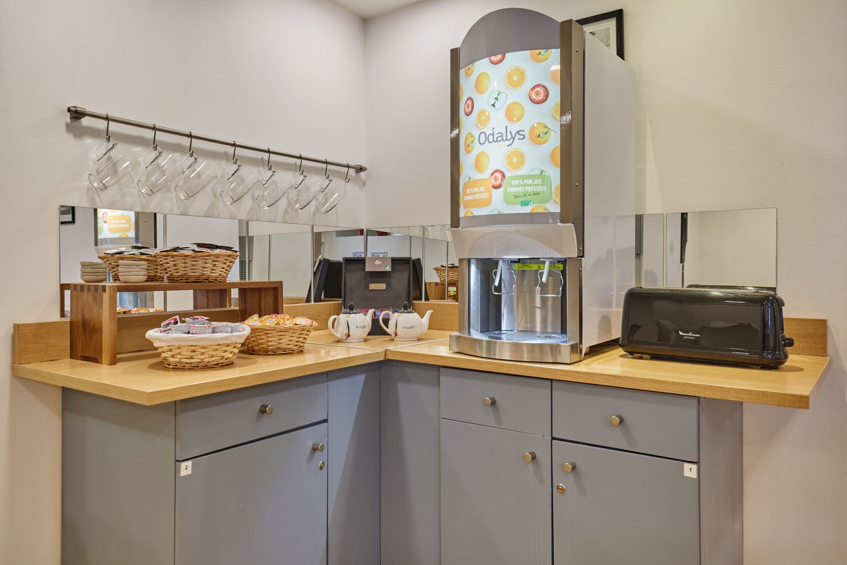 A kitchenette with a coffee machine, toaster, and tea set.