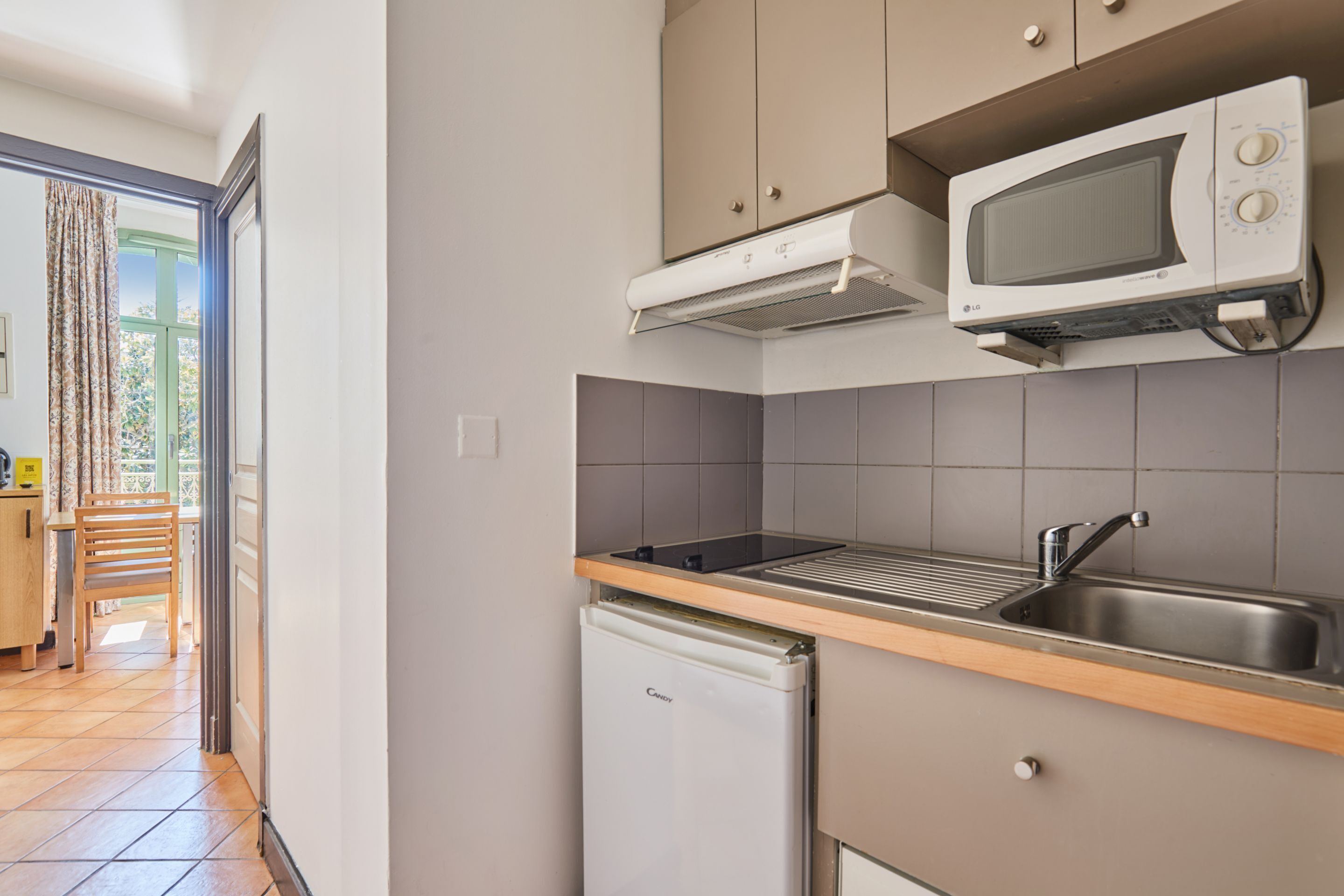A kitchen with a microwave, sink, and refrigerator.