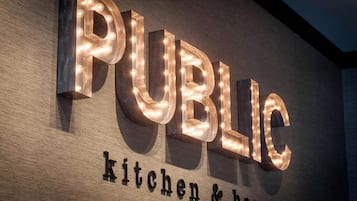 Letras iluminadas que dicen "PUBLIC" con "cocina y bar" debajo.
