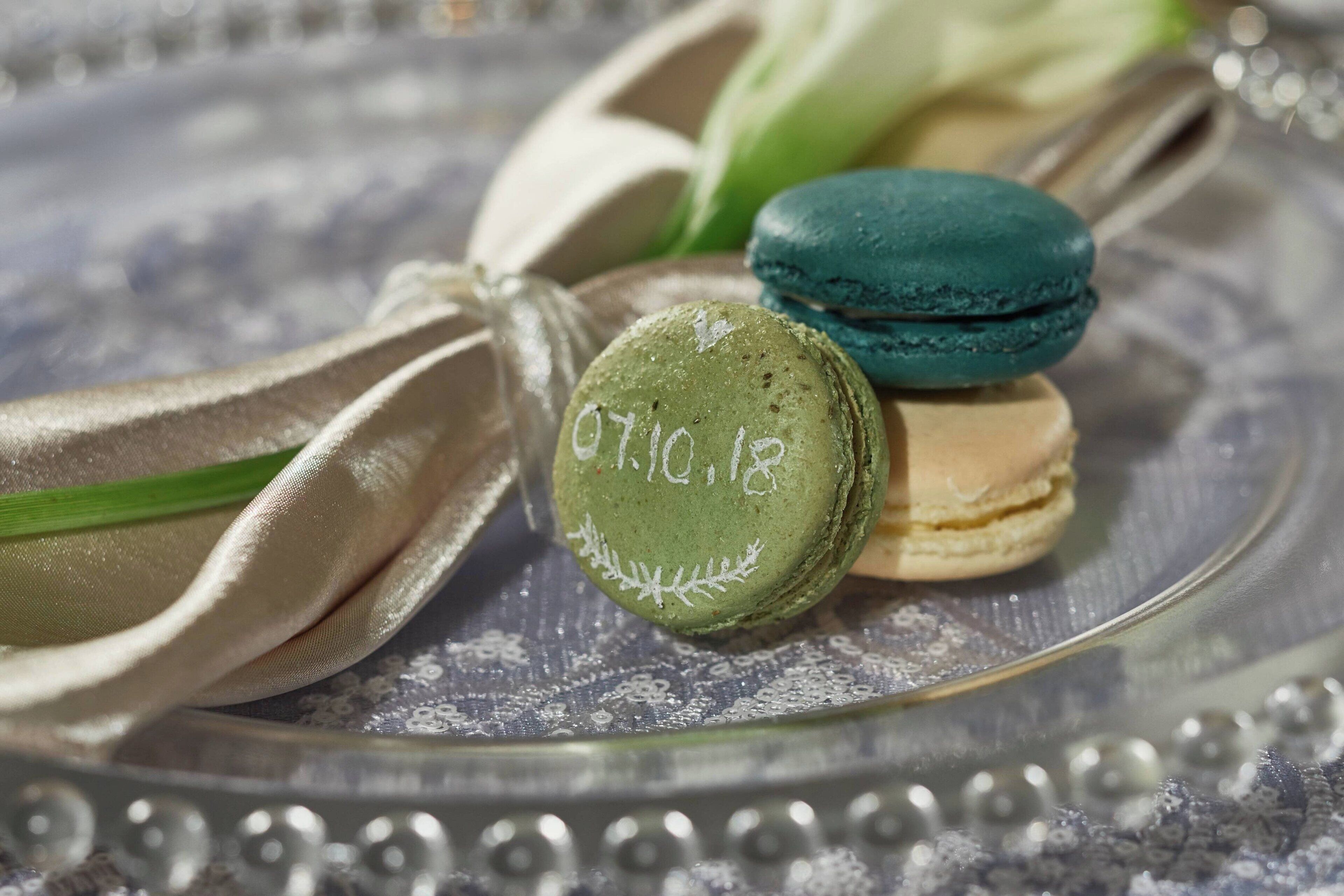 A plate with three macarons and a ribbon.