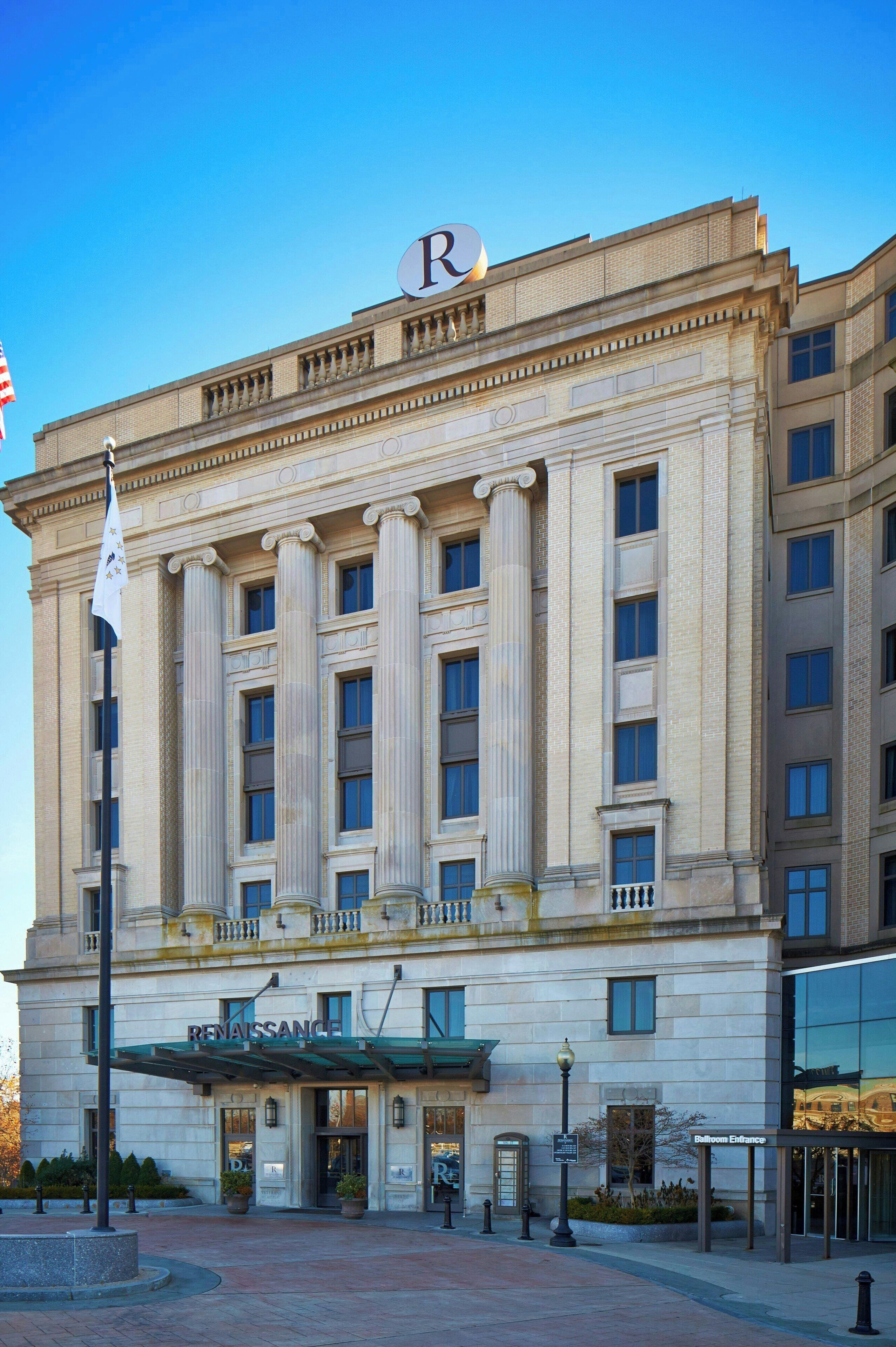 A Renaissance hotel with a classical facade, large columns, and a prominent 'R' on the top.