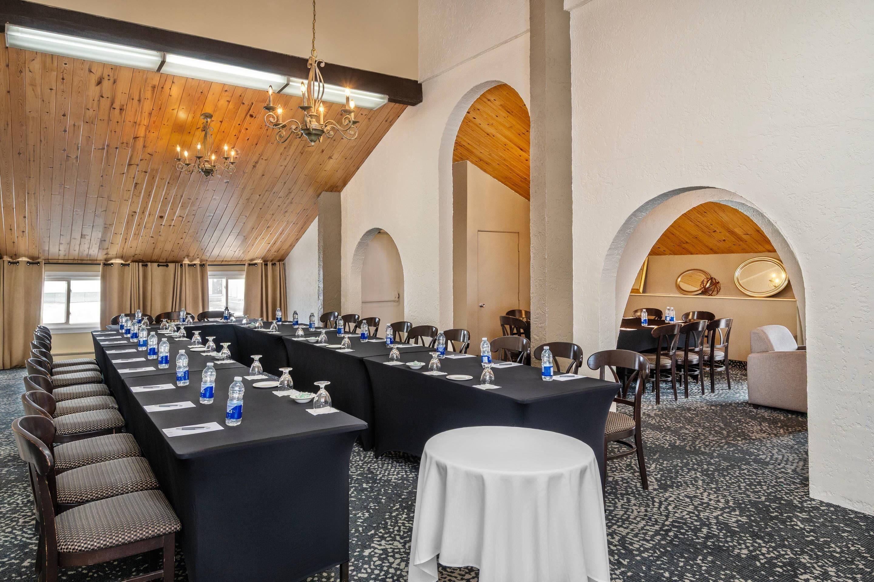 Un salón de conferencias con una larga mesa, sillas y una araña.