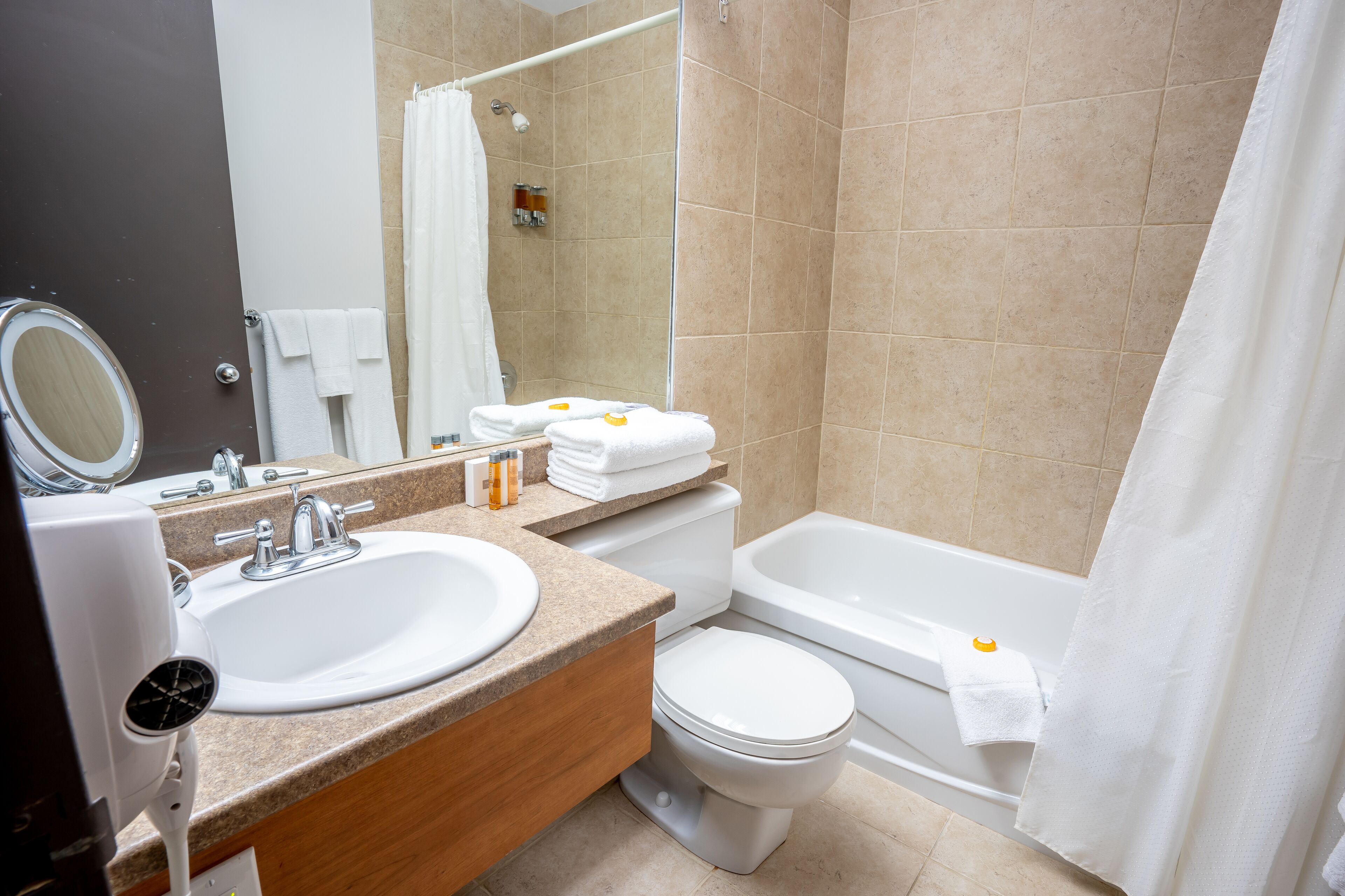 A modern bathroom with a sink, toilet, and bathtub.