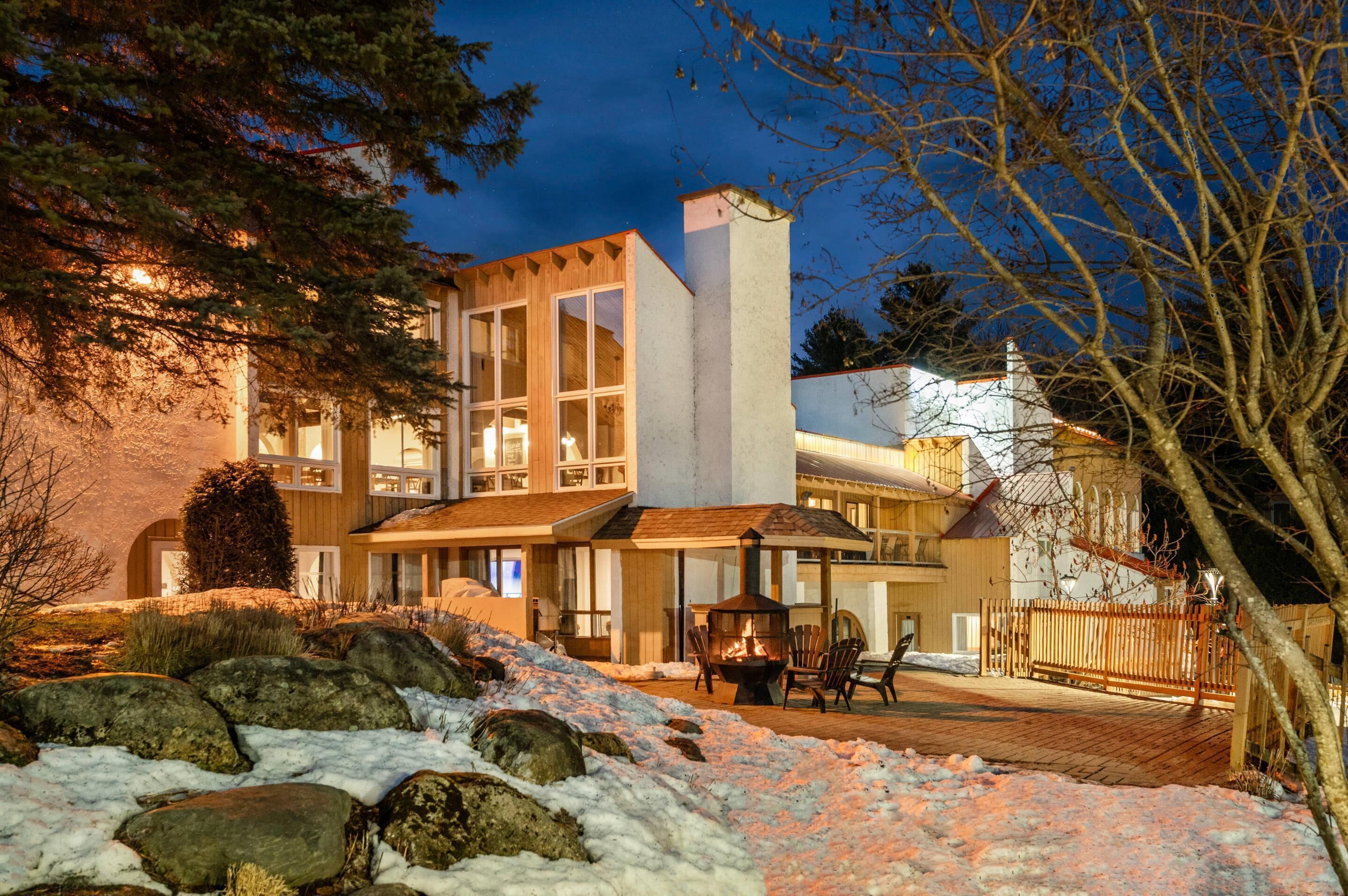 A modern building with large windows, a fireplace, and a deck area.