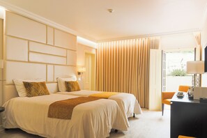 Une chambre d’hôtel avec deux lits, un bureau et une chaise.