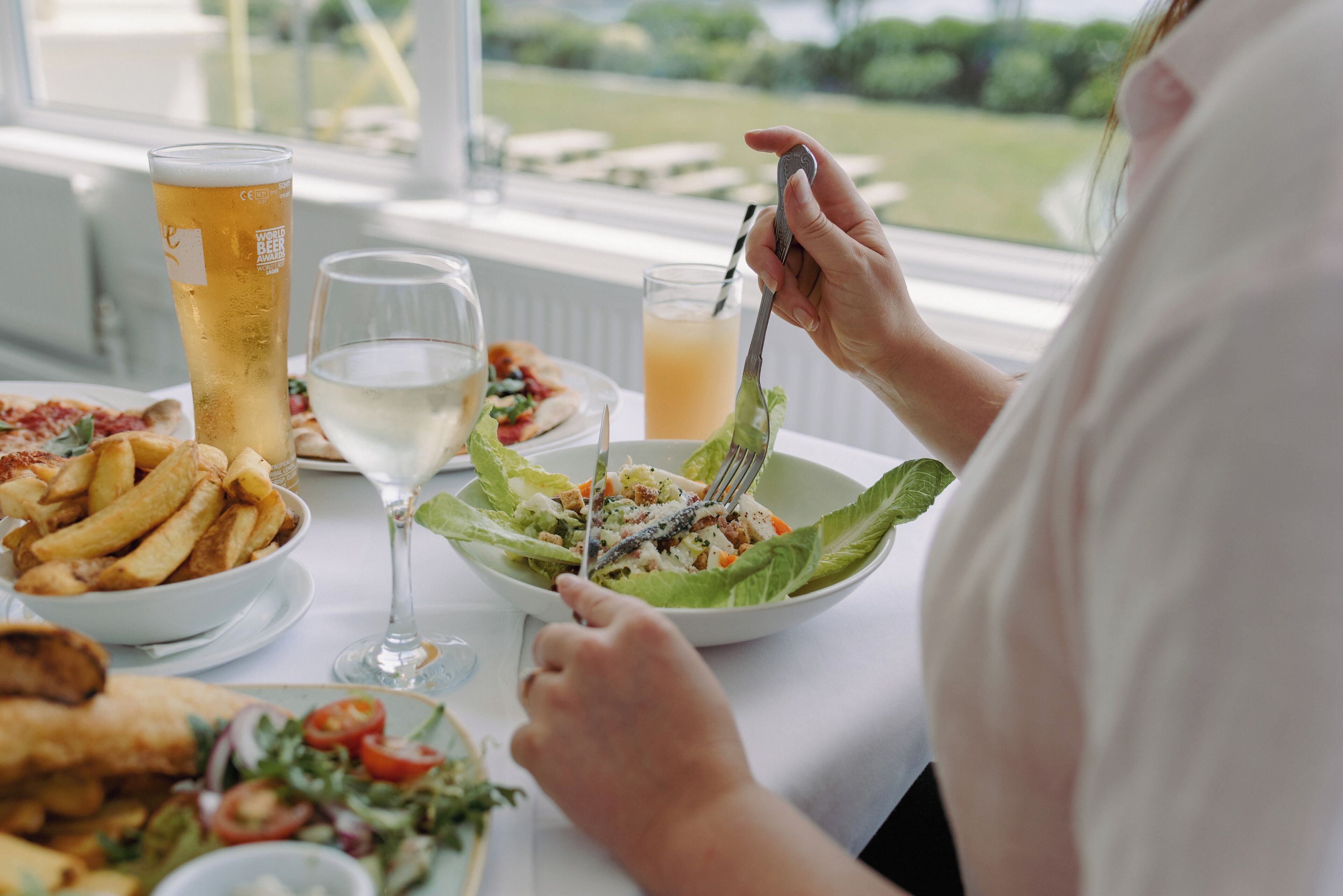 A dining table with various dishes including a salad, fries, and a fish dish.