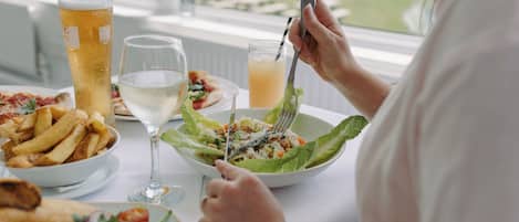 A dining table with various dishes including a salad, fries, and a fish dish.