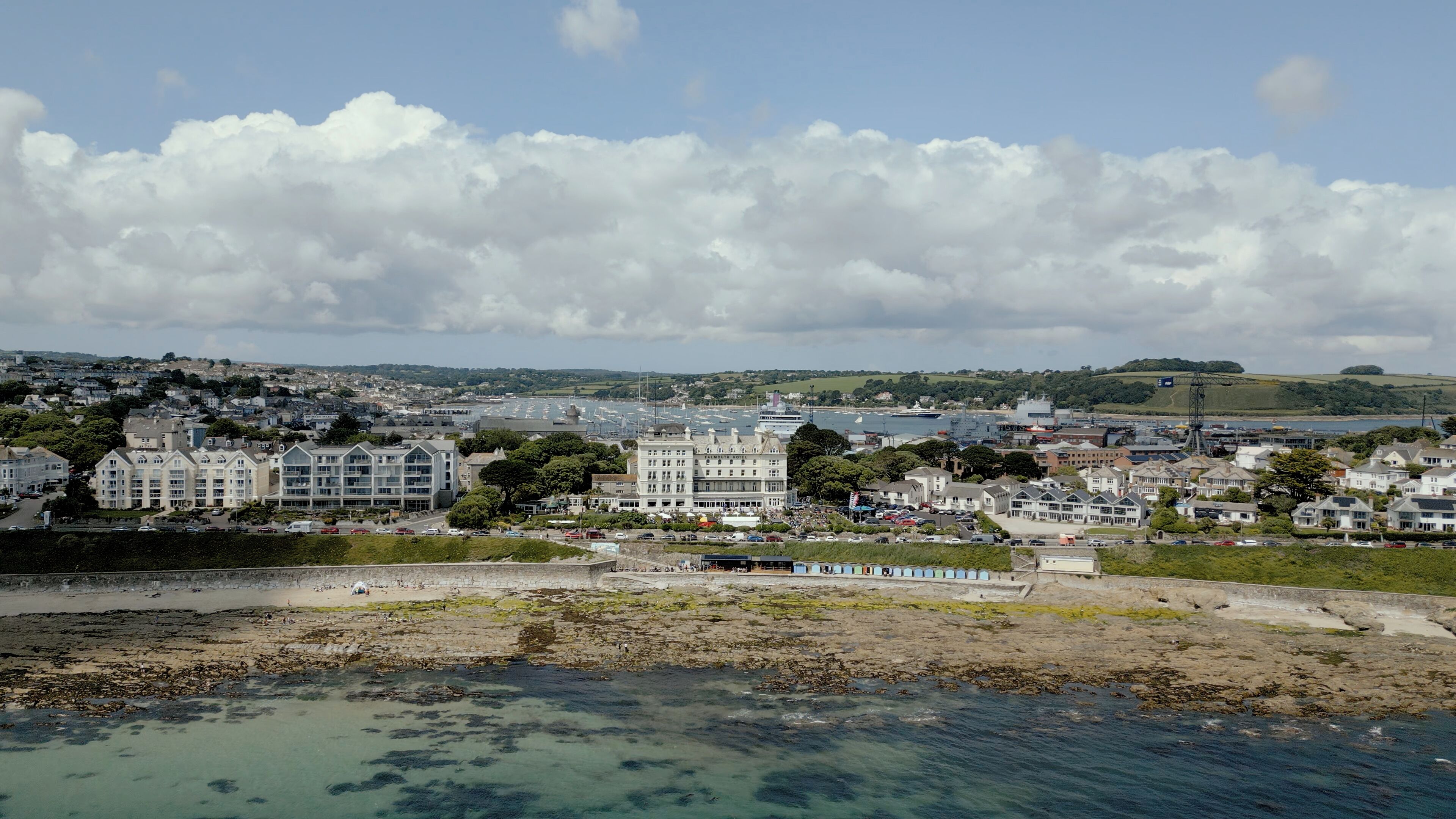 Une ville côtière dotée d’un port de plaisance, d’immeubles résidentiels et d’une côte rocheuse.