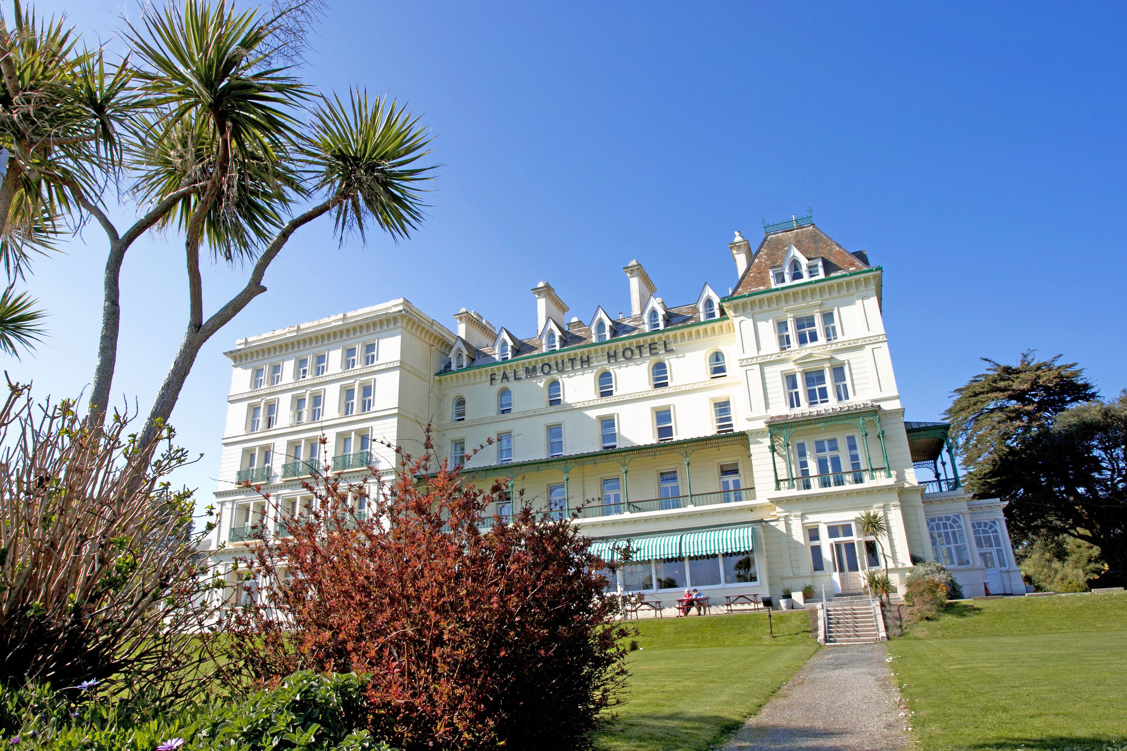 A large, multi-story hotel with a classic architectural style, featuring a prominent entrance and a well-maintained garden.