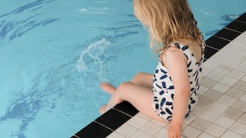 Children can enjoy a refreshing swim in the pool surrounded by a decorative tile border.