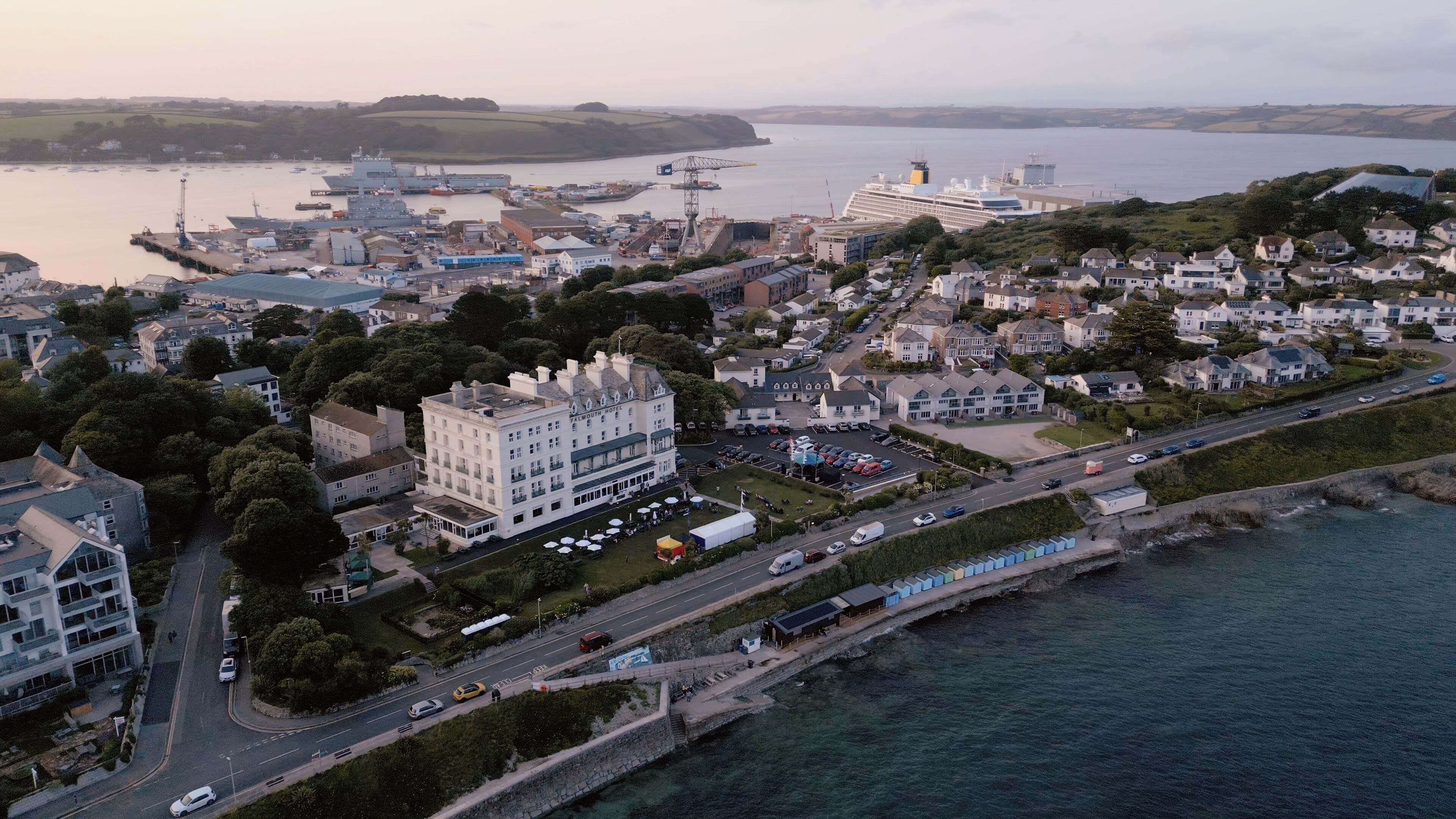 An aerial view of a coastal town with a prominent hotel, a marina, and residential areas.