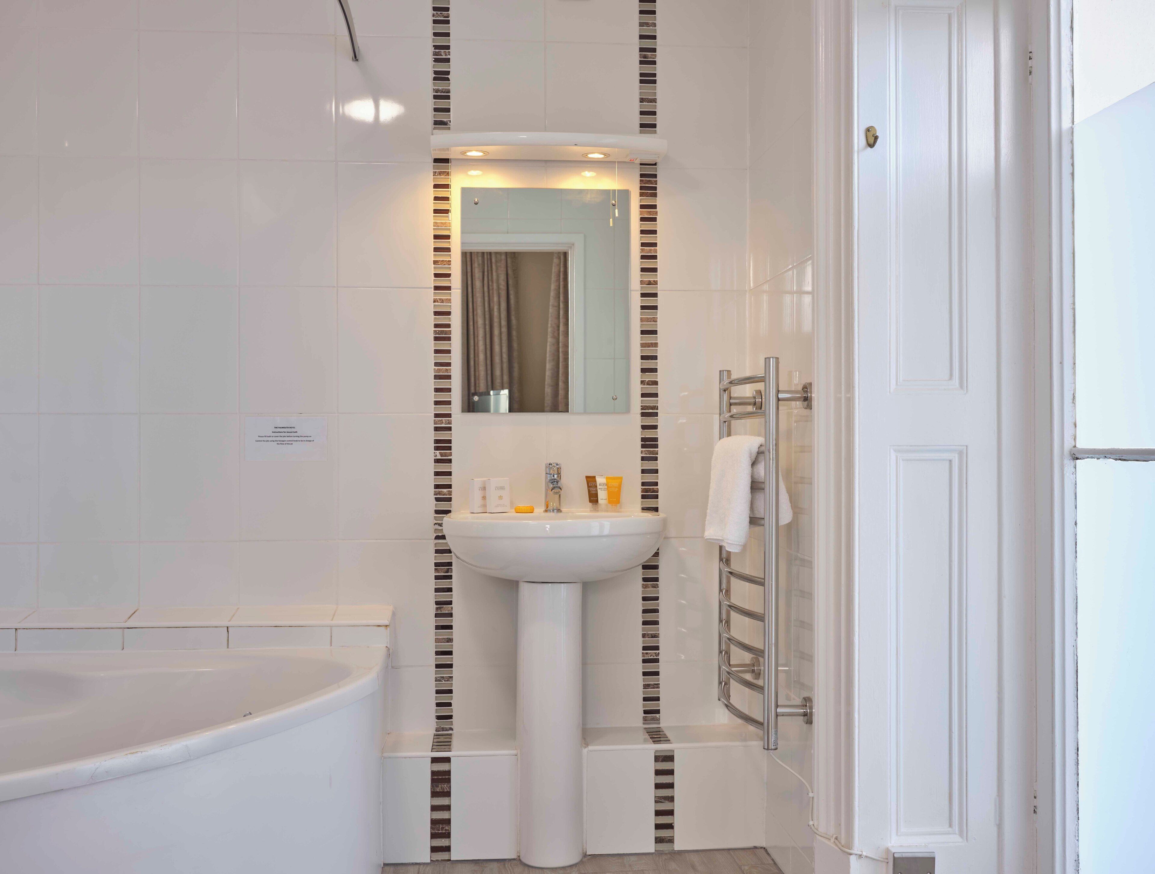 Ein modernes Badezimmer mit Waschbecken, Spiegel und Badewanne.