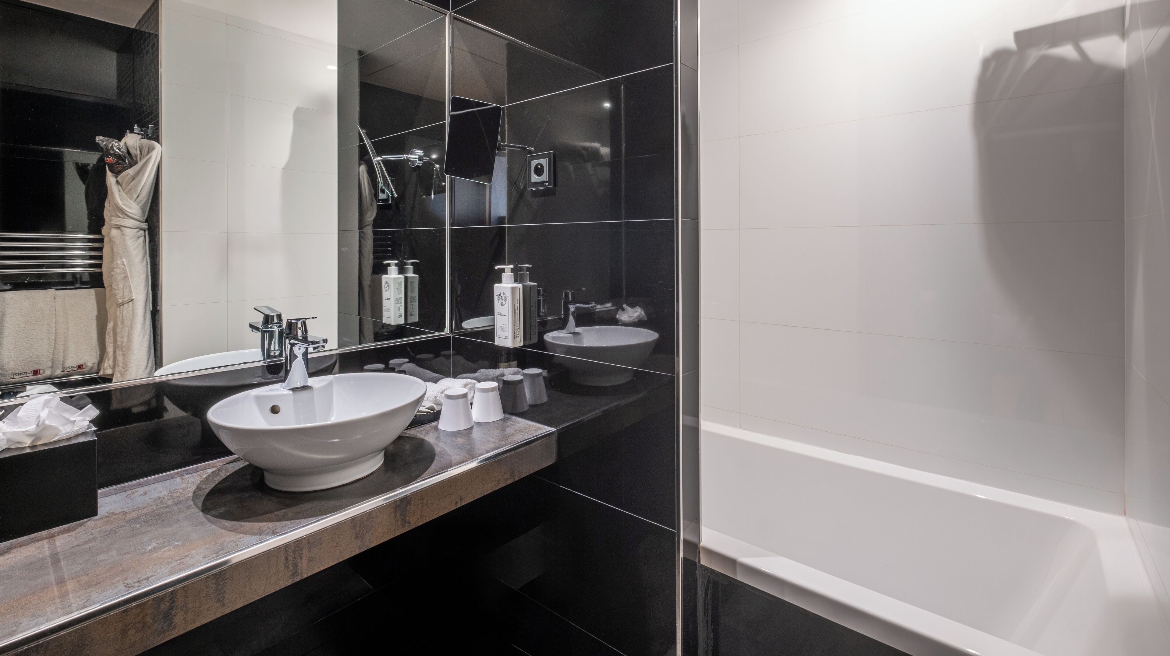 Een moderne badkamer met een grote spiegel, een wastafel en een bad.