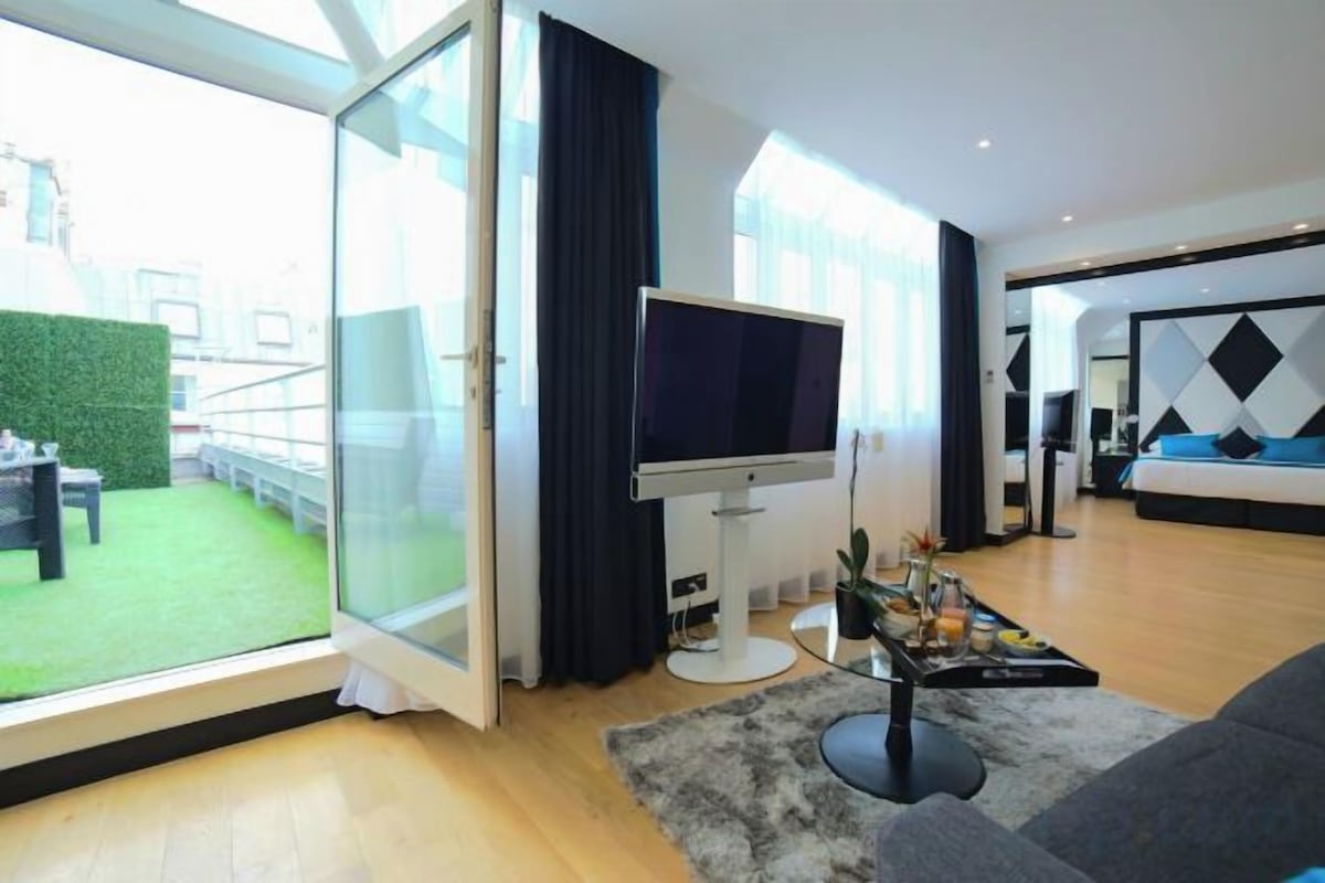 Una sala de estar moderna con un televisor grande, un sofá y una mesita de centro.