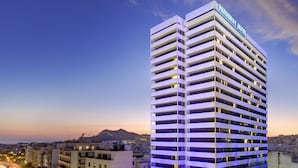 A high-rise hotel with a modern design, featuring multiple balconies and a prominent signage. - President Hotel Athens (Athens)