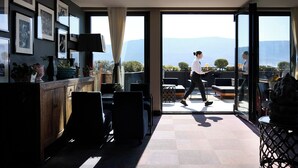 A modern hotel room with a large sliding glass door leading to an outdoor terrace with a mountain view. - President Hotel Athens (Athens)