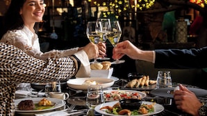 A restaurant setting with a table set for a meal, including plates of food, glasses, and a pitcher of water. - President Hotel Athens (Athens)