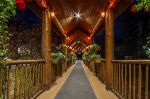A wooden covered walkway with railings, leading to a building entrance. - Auberge du Lac Taureau (Saint-Michel-des-Saints)
