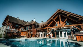 Alberca techada, alberca al aire libre y sombrillas en la alberca