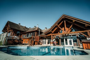 Una piscina cubierta, una piscina al aire libre, sombrillas, tumbonas