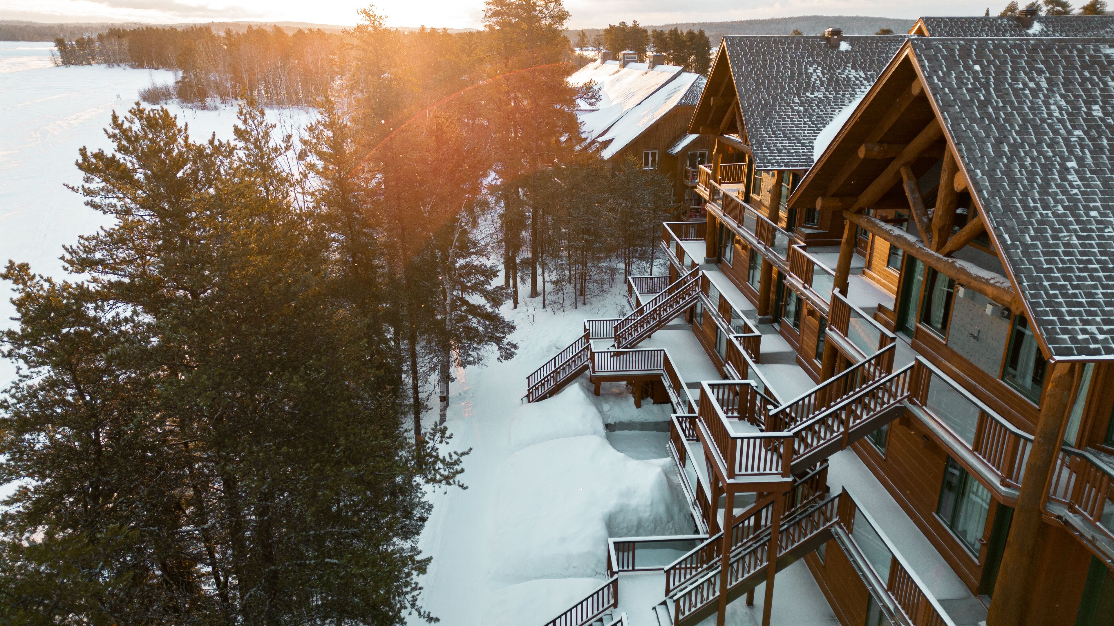 Een lodge met meerdere balkons en een besneeerd landschap.