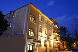 Ein mehrstöckiges Hotel mit klassischer Architektur, große Fenster und eine gut beleuchtete Fassade.