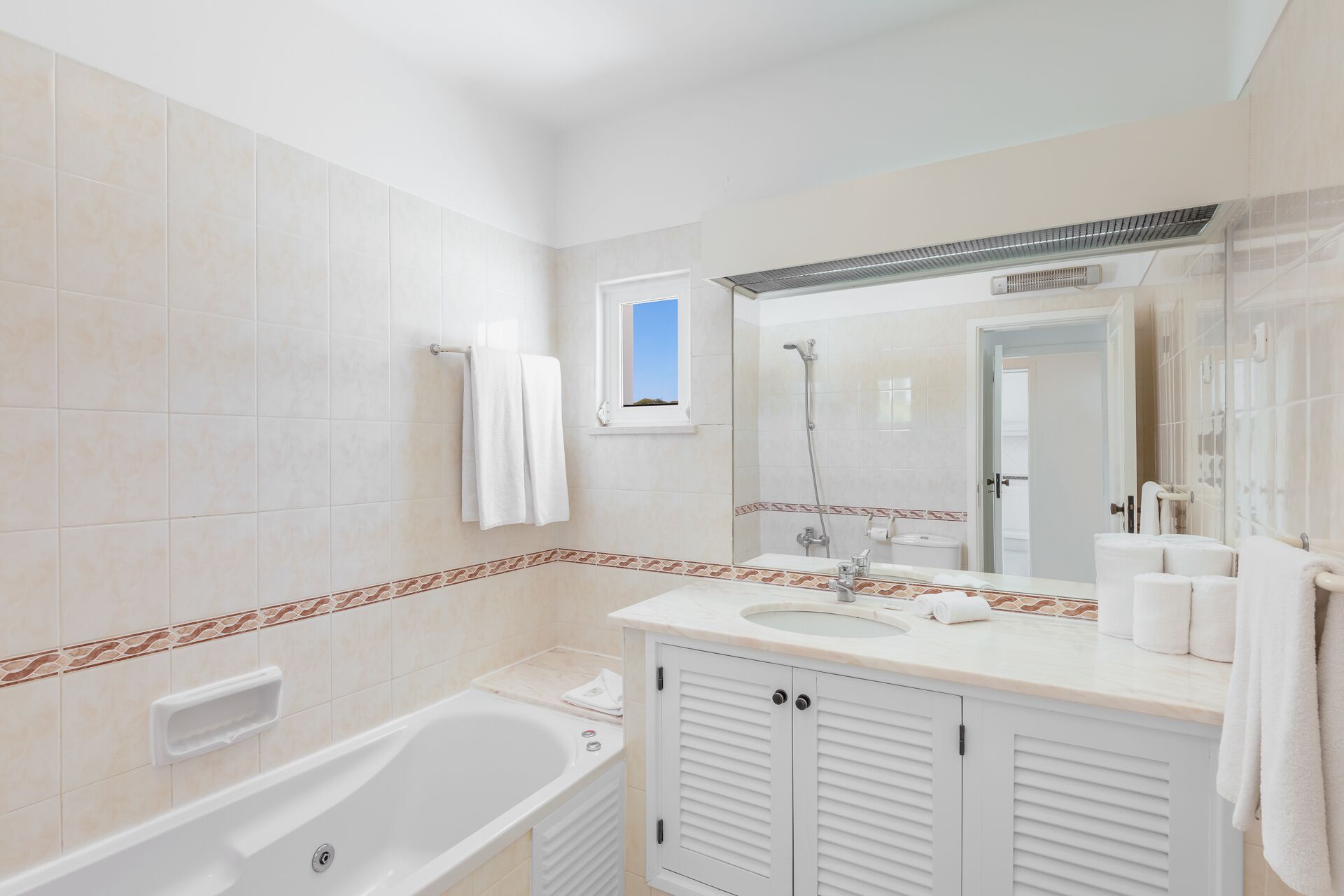 Une salle de bain moderne avec une baignoire, un grand miroir et une douche.